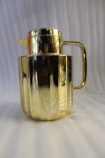 One More 1 liter luxury polished gold vacuum insulated flask with a fluted ribbed design on a marble countertop.