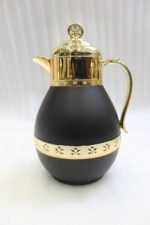 Three luxury 1-liter thermal coffee and tea vacuum flasks with ornate gold lids and accents in matte black, cream, and taupe on a granite kitchen countertop.